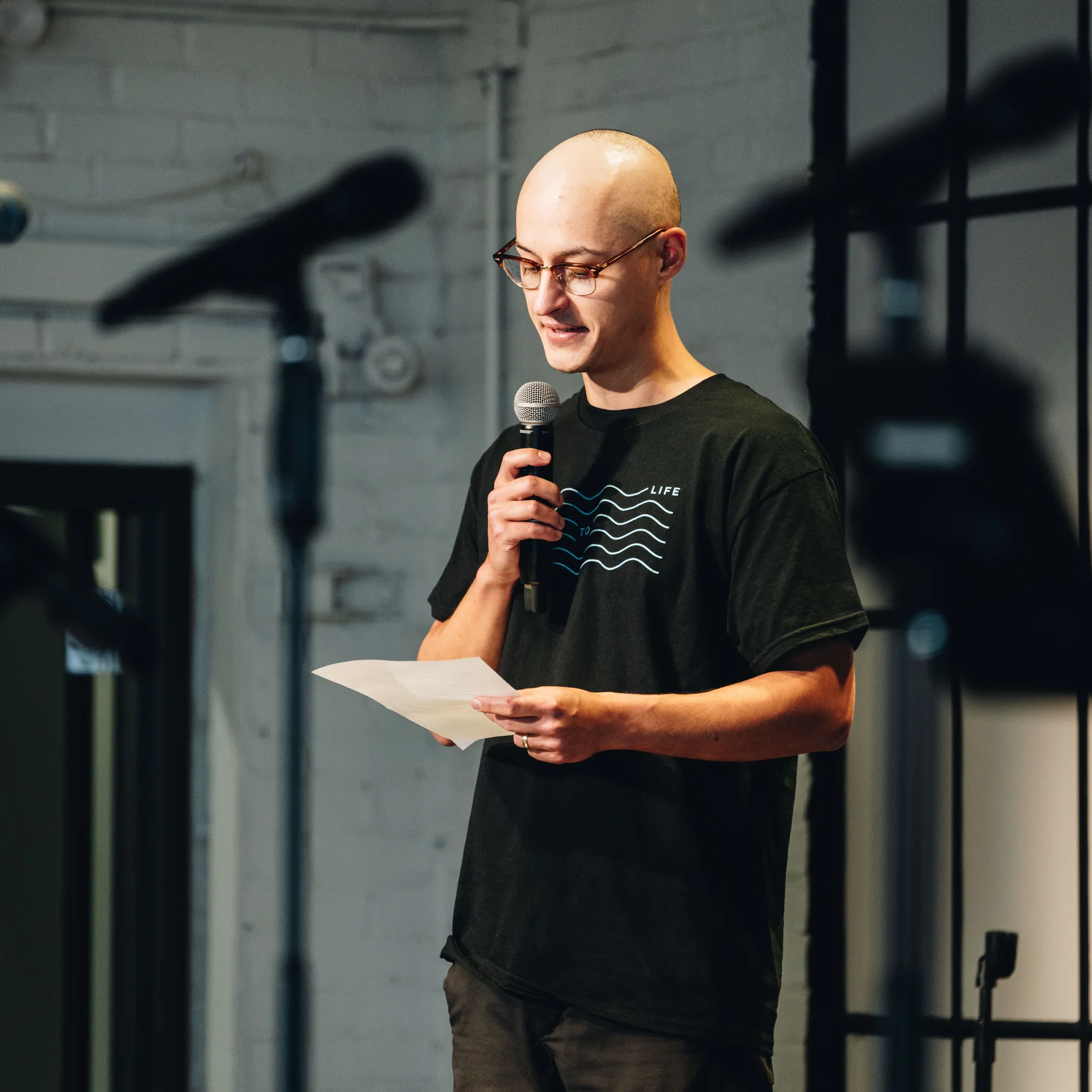 Tyler speaking into a microphone during his baptism