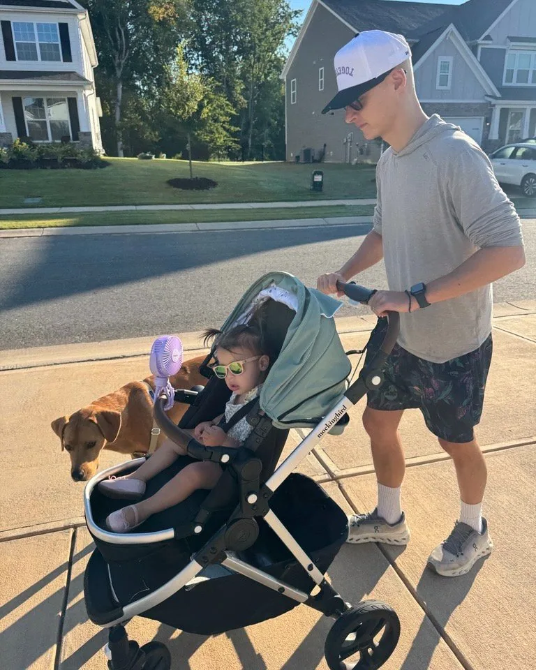 Tyler pushing Lucia in her stroller while walking the family dog